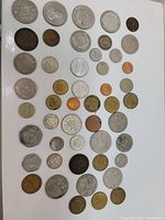 Overview of a variety of coins showing different sizes, metals, and designs arranged on a white background.