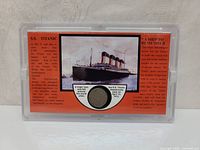 Commemorative plastic plaque featuring image and text about the S.S. Titanic, with a 1912 US V Nickel coin encased in the center below the ship's image.