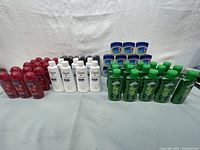 Photo showing multiple red Softsoap body wash bottles, white Dove lotion bottles, green Suave shampoo bottles, and blue Vaseline tubs arranged in rows.