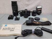 The main lot contents showing camera body, lenses, flash unit, strap, manual, remote cable, and battery charger.