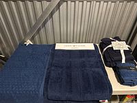 Photo showing a navy Tommy Hilfiger towel and a matching textured towel or rug in dark blue.