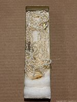 Multiple strands of coral pearl necklaces with gold-tone clasps in a jewelry box.