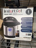 Box of Instant Pot Smart WiFi 6-quart multi-function pressure cooker showing brand, model, features and capacity.