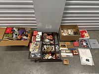 Overview of entire lot on floor: two cardboard boxes, glass display tray, assorted loose items.
