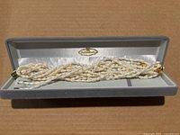Entire multi-strand necklace displayed in open grey Mitsukoshi box