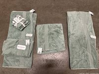 Full view of spread out Pavilion towels showing multiple towel sizes and included washcloth bundle.