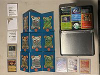 Full overhead shot of the Pokemon cards, display board, tin, and loose cards