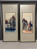Pair of two framed signed artworks featuring architectural scenes.
