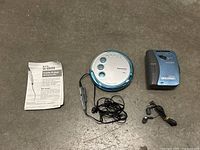 Overview of Panasonic SL-SX420 CD player, Sony WM-FX153 Walkman, original Panasonic manual, and earphones on floor.