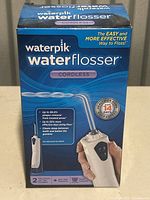 Photo of sealed retail box of Waterpik cordless water flosser showing front label and product information.