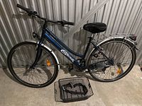 Full side view of the women's California cruiser bicycle, reveals step-through frame, front basket on ground, rear rack, and reflectors on wheels.