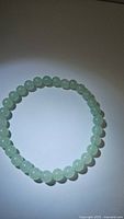 Top-down view of the green aventurine beaded bracelet showing the whole circle of beads on white background.