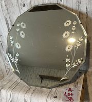 View of antique octagonal mirror showcasing floral etching and beveled edges