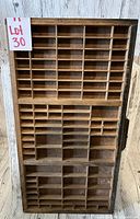 Front view of the antique wooden letterpress printers drawer displaying compartments.
