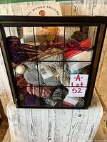 Full view of yarn, books, and tools in glass/metal/wood basket