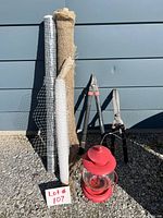 Photo showing six outdoor garden tools and supplies including rolls of fencing, burlap, tree wrap; pruning and hedging shears; and red bird feeder lantern.