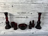 All seven pieces of the Avon Ruby Red Cape Cod Collection displayed together on a grey wooden background.