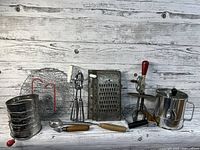 Lot of vintage kitchen baking tools and accessories arranged on wooden background.