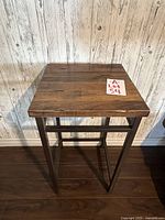 Front view of square wood top table with metal frame and legs.