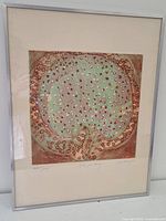 Overall view of framed lithograph leaning against wall