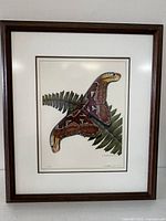 Framed print showing the detailed Atlas Moth on fern leaf with wooden dark frame and white matting.