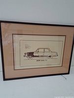 Full view of framed print depicting BMW 2002 Tii car in sepia line art style, showing entire frame and matting.