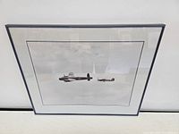 Front view of framed photograph showing the Lancaster bomber and Spitfire flying in formation in the sky.