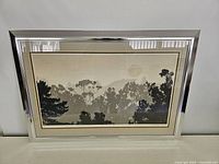 Framed print showing full artwork and reflective silver-tone frame.