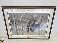 Full front view of framed artwork showing bull moose in forest scene