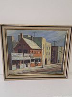 Framed oil painting showing full street scene