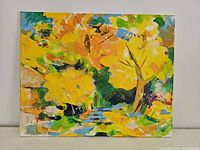 Full view of the oil on canvas painting showing the colorful abstract autumn landscape with yellow leaves, green foliage, and blue water.