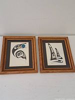 Pair of framed prints on white background, showing full frames and artwork.