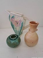 Photo showing all three ceramic vessels with distinct shapes and color schemes.