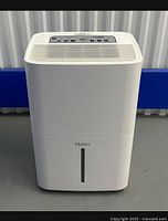 Front view of white Haier dehumidifier showing logo and water level indicator.