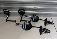 Four African decorative items shown: two wall hangers with face motifs and two candle holders