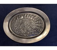 Top view of the vintage aluminum oval serving platter with embossed turkey design, showing polished rim and detailed feathers.