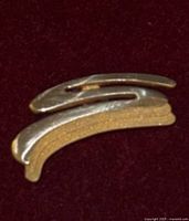 Front view of the 10 KT gold pin showing its curved shape and dual tone design
