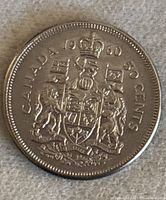 Obverse showing Canadian coat of arms, crown, year and denomination