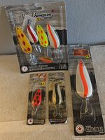 Front view of the four fishing lures in factory packaging showing colors and designs
