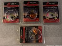 Four Matzuo Sickle Rig fishing lures in original factory packaging laid out on a surface, showing front of the packages.