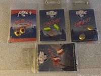 Five Bob-it fishing lures in original packaging, showing variety of spinner and spoon styles with different colors.
