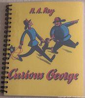 Front spiral-bound cover of Curious George children's braille book in yellow with characters.
