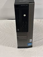 Front view of Dell OptiPlex 3020 desktop computer tower showing DVD drive, USB ports, audio jacks, and logo stickers.