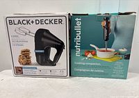 Front view of two boxes side by side: Black+Decker 6-speed hand mixer and Nutribullet immersion blender.