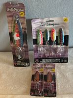 Photo of one single colorful Len Thompson Dimpled Series fishing lure and one pack of four assorted color lures in factory packaging.