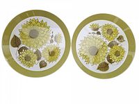Top view of two vintage Mikasa Duplex by Ben Seibel serving plates featuring detailed green and yellow Dahlia flower patterns with leaves and olive green rim on white porcelain.