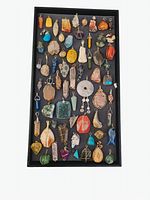 Full view of tray holding 68 wire wrapped pendants made of various semi-precious stones and shells showing color and wire wrapping details.
