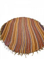 Full view of the circular striped jute rug laid flat showing the fringe edge and full pattern.