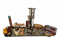 Full view of entire lot on glass table showing carvings, baskets, jewelry, books and pouches