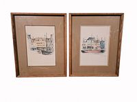 Front view of two framed watercolor prints showing detailed cityscape scenes with sailboats and historic buildings, signed by Mads Stage.